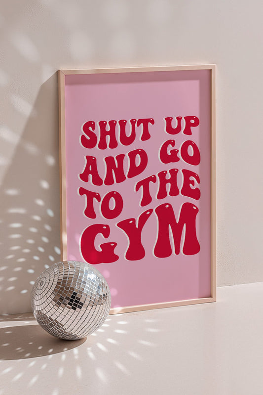 Motivational gym wall art with "Shut Up and Go to the Gym" in retro font on a pink background.